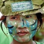 A woman with a painted face attends a protest at the Freedom Park in Phnom Penh May 25, 2011. About 100 local activists attended a demonstration and news conference appealing to the government to save Prey Lang forests in Kompong Thom, Stung Treng, Kratie and Preah Vihear provinces and demanding to stop granting economic land concessions and suspend all those already granted. Protesters, who call themselves Cambodia's "Avatars", had their bodies painted in green and blue and wore traditional ethnic Kuy clothes, including hats made from tree materials. REUTERS/Samrang Pring (CAMBODIA - Tags: ENVIRONMENT POLITICS ODDLY CIVIL UNREST)