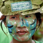 A woman with a painted face attends a protest at the Freedom Park in Phnom Penh May 25, 2011. About 100 local activists attended a demonstration and news conference appealing to the government to save Prey Lang forests in Kompong Thom, Stung Treng, Kratie and Preah Vihear provinces and demanding to stop granting economic land concessions and suspend all those already granted. Protesters, who call themselves Cambodia's "Avatars", had their bodies painted in green and blue and wore traditional ethnic Kuy clothes, including hats made from tree materials. REUTERS/Samrang Pring (CAMBODIA - Tags: ENVIRONMENT POLITICS ODDLY CIVIL UNREST)
